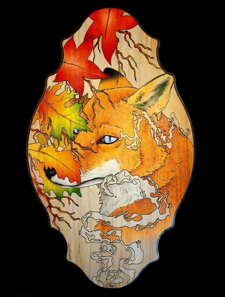 the face of a red fox with blue eyes is partially shrouded with maple leaves in fall colors of red, green, and yellow. Ihe style of the illustration is realistic. It is surrounded by misty wisps in the style of impressionism. It is rendered in colored pencil and black ink on a scrolled edge oval wooden board. The background is solid black to help the colors on the canvas be vibrant.