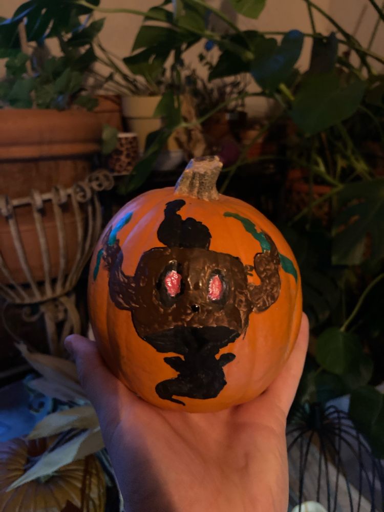 Image of a hand sized pumpkin with the ghost type Pokémon Phantump painted on it