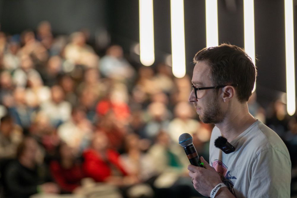 Matthieu Lux holding a microphone during his talk at the first LyonJS conference.