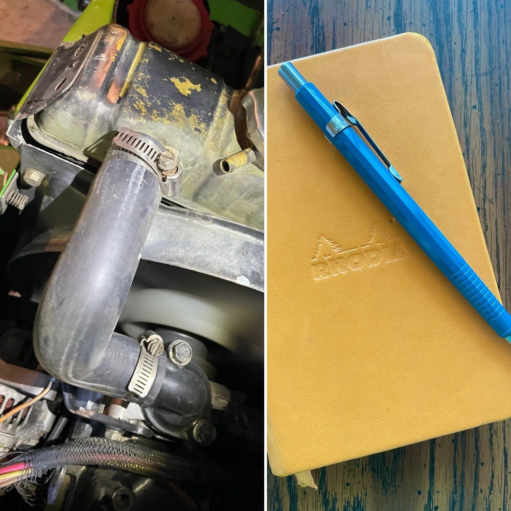 Left side of image shows a small tractor engine with black rubber hose. Right side of image shows an orange notebook and blue mechanical pencil. 