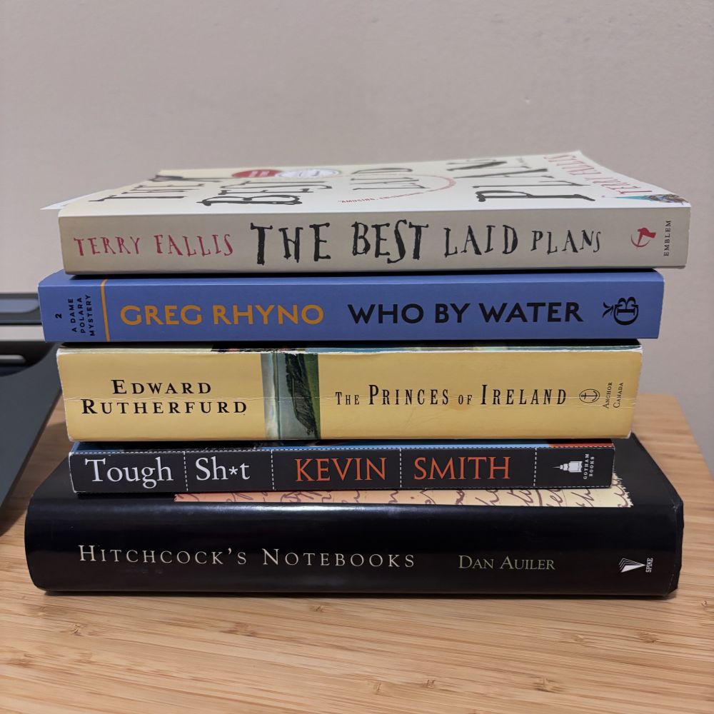 Stack of books - Hitchcock’s Notes, Tough Shit by Kevin Smith, The Princes of Ireland by Edward Rutherford, Who By Water by Greg Rhyno, The Best Laid Plans by Terry Fallis 