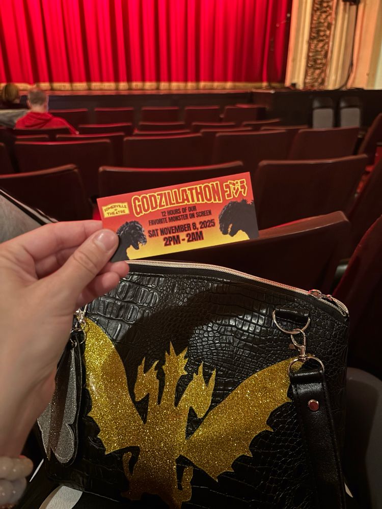 a theater with a godzilathon ticket being held up 