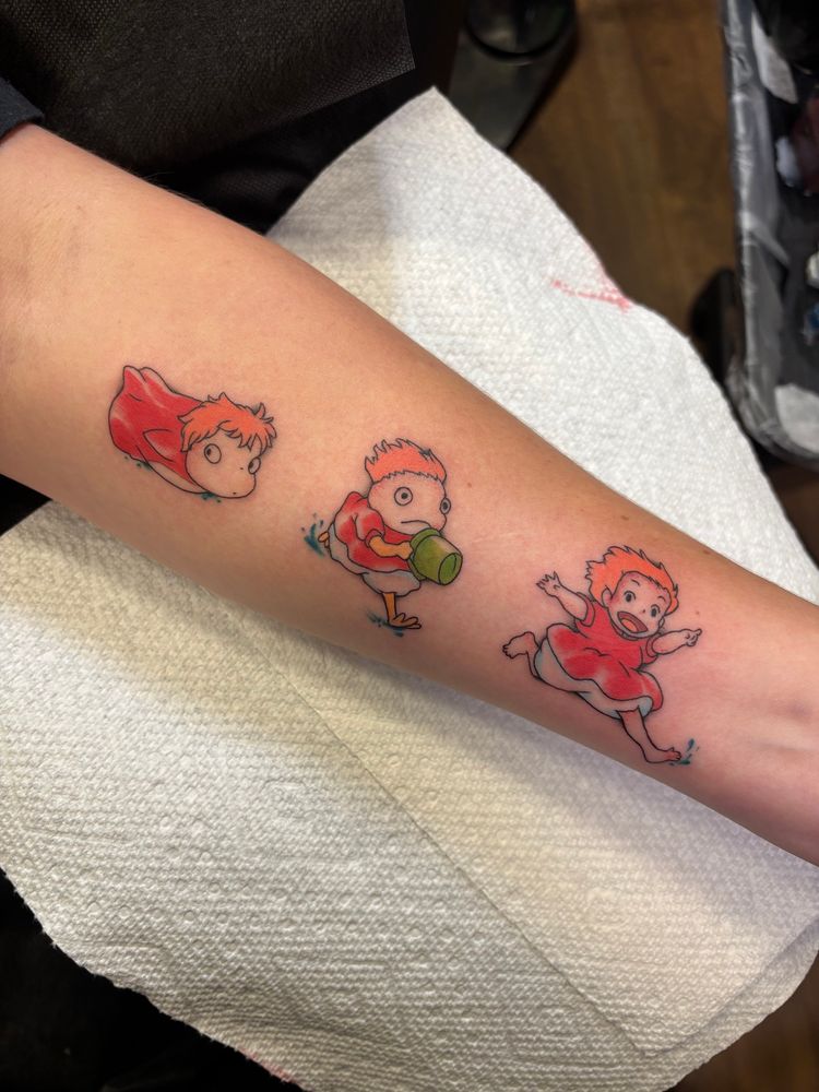 a white forearm, with three small color tattoos of Ponyo. Left to right: Ponyo as a fish, Ponyo with chicken legs, and Ponyo as a human girl. 