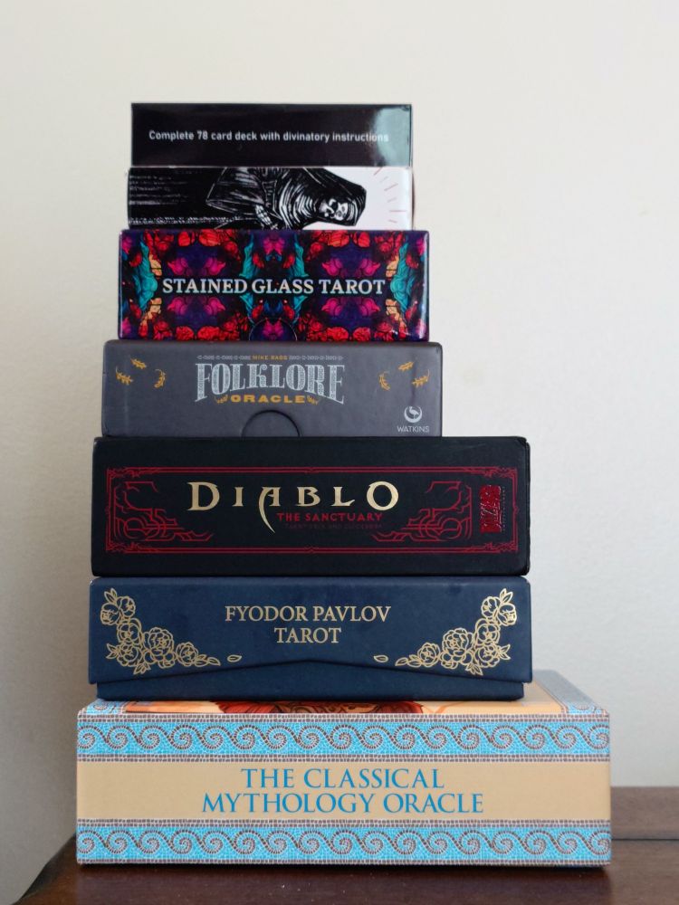 A stack of tarot and oracle decks
From top to bottom:
The Cocaine Tarot
The Flux Arcana Tarot
Stained Glass Tarot
The Folklore Oracle Deck
Diablo: The Sanctuary Tarot
Fyodor Pavlov's Tarot
The Classical Mythology Oracle Deck