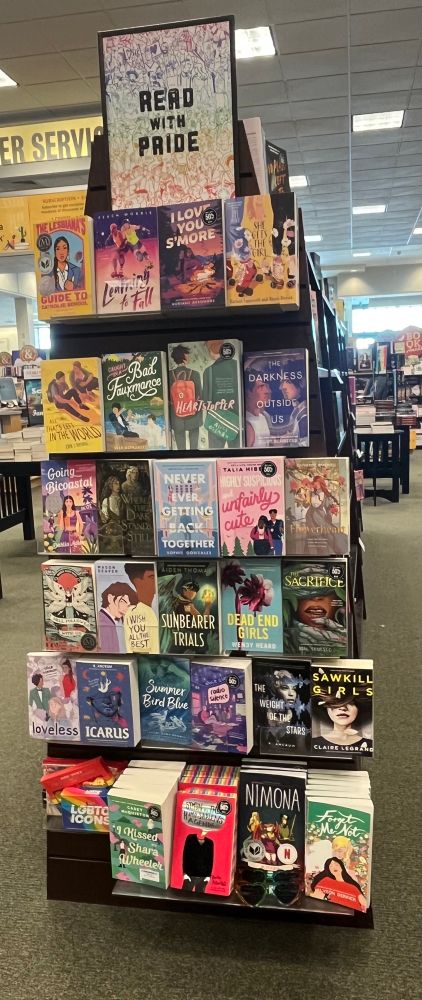 First shelf: The Lesbiana's Guide to Catholic School (Reyes), Learning to Fall (Morris), I Love You S'more (Desombre), She Gets the Girl (Lippincott & Derrick)

Second Shelf: All That's Left in the World (Brown), Caught in a Bad Fauxmance (Rose), Heartstopper Vol. 1 (Oseman), The Darkness Between Us (Schaeffer)

Third Shelf: Going Bicoastal (Adler), Where the Dark Stands Still (Poranek), Never Ever Getting Back Together (Gonzales), Highly Suspicious and Unfairly Cute (Hibbert), Flowerheart (Bakewell)

Fourth Shelf: Hell Followed With Us (White), I Wish You All the Best (Deaver), The Sunbearer Trials (Thomas), Dead End Girls (Heard), The Sacrifice (Chupeco)

Fifth Shelf: Loveless (Oseman), Icarus (Ancrum), Summer Bird Blue (Bowman), Radio Silence (Oseman), The Weight of Stars (Dow), Sawkill Girls (Legrand)

Bottom Shelf: I Kissed Shara Wheeler (McQuiston), Simon vs. the Homo Sapiens Agenda (Albertelli), Nimona (Stevenson), Forget Me Not (Derrick)