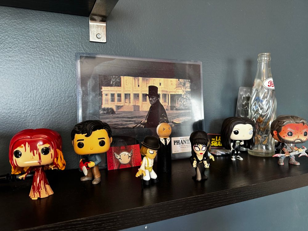 The tall man and an assortment of small funkos horror division hanging out on a shelf 