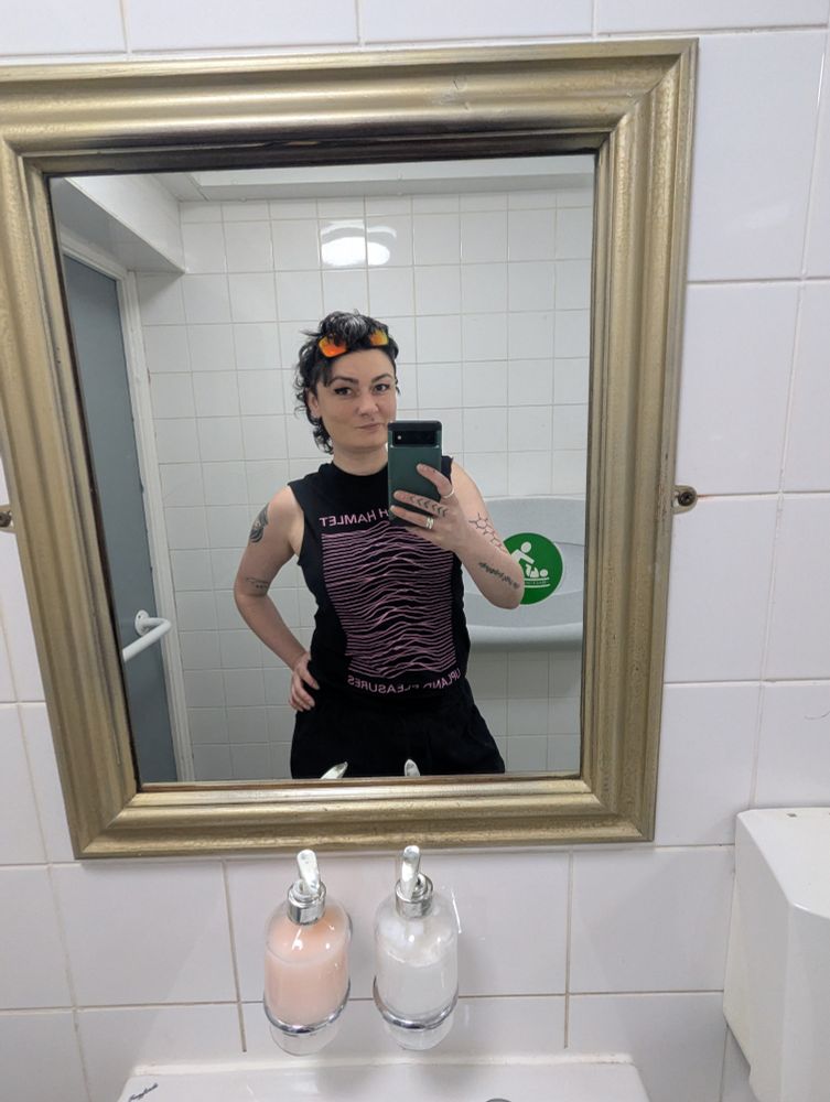 Me in the Dulwich Hamlet Uplands Pleasures shirt which looks like the Joy Division Unknown Pleasures shirt but it's hills not whatever the waves on that are. also I've cut the sleeves off so you can see my sick tattoos etc 