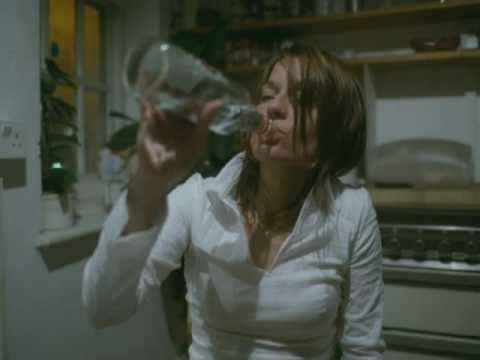 a screenshot from Massive Attack's video for Live With Me showing a dishevelled woman downing an entire bottle of vodka