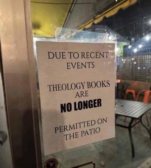 Sign on storefront. "Due to recent events theology books are no longer permitted on the patio"