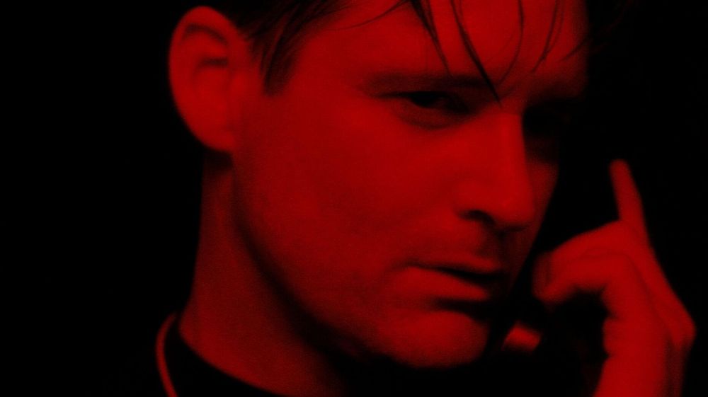 Still from 'Lost Highway', Bill Pullman's character's face lit up in red while he's on the phone