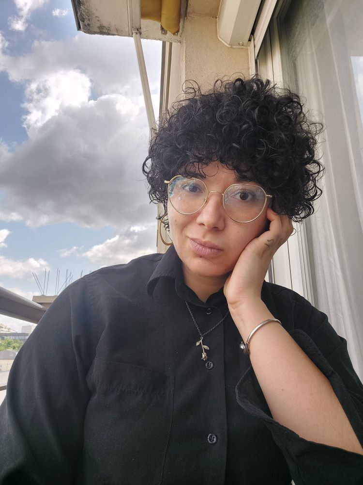 Selfie habillée en chemise noire avec un pendentif doré 