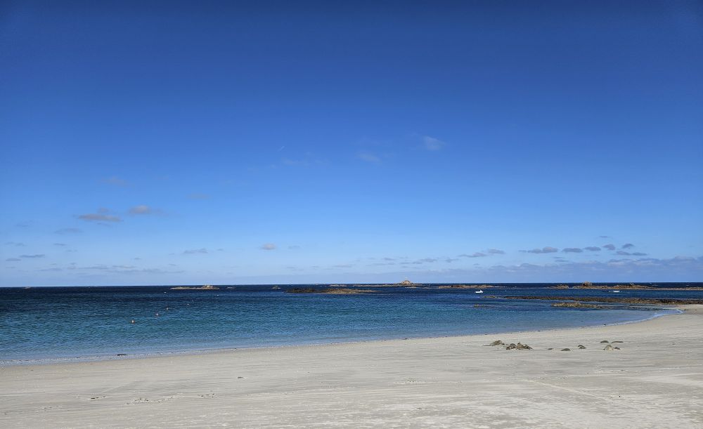 A white sand beach with topaz water that does not look like it's the British isles. 