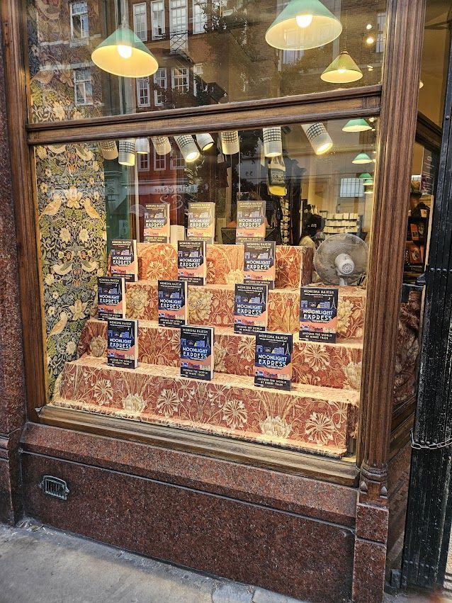 Daunt Marylebone's window display of Moonlight Express, with lots of copies aginst a patterned, stepped background. 