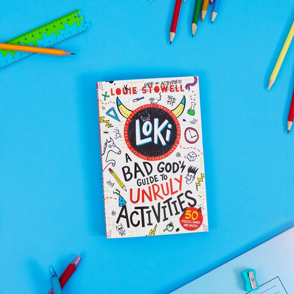 A copy of LOKI: A Bad God's Guide to Unruly activities: 50 puzzles, games and quizzes. It's laid on a bright blue background with various school props like pens, sharpener, notebook, ruler, pencils. The cover is a scribbly load of doodles with the word LOKI big in the middle with a circle around it, horns sprouting either side. No, viking helmets did NOT have horns but Loki likes to add them everwhere to troll archeologists.  Oh and the book is by me, Louie Stowell, but on the cover my name is par scribbled out to make it into Loki God of Asgard.