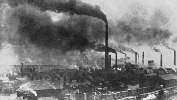 A black and white photo of chimneys belching smoke in birmingham at some point in the past, maybe the 1950s? I'm not THAT old but it's definitely the same vibe that birmingham gave in the 80s when I was going past on the train to liverpool. 