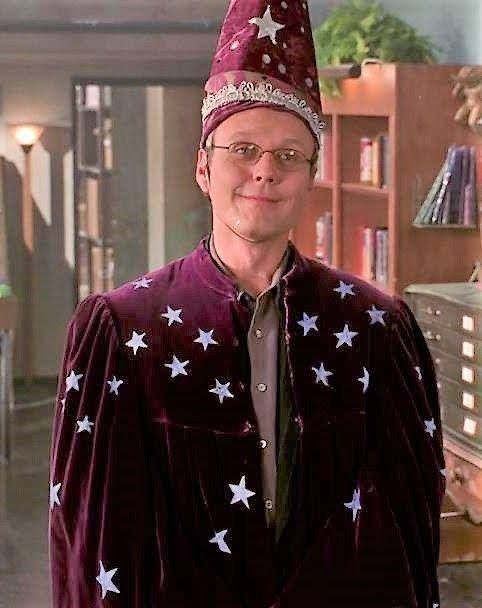 Giles from Buffy in a scene in the magic shop where he is looking epically dorky in a wizard outfit. 