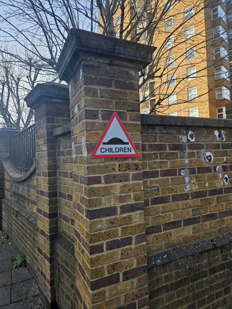 A bump in the road triangle warning street sign with CHILDREN written on it.
