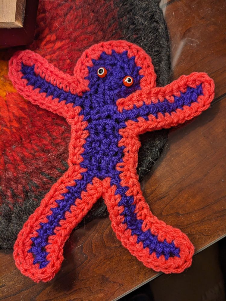 Small crochet yarn person with bead eyes. Made with acrylic yarn.