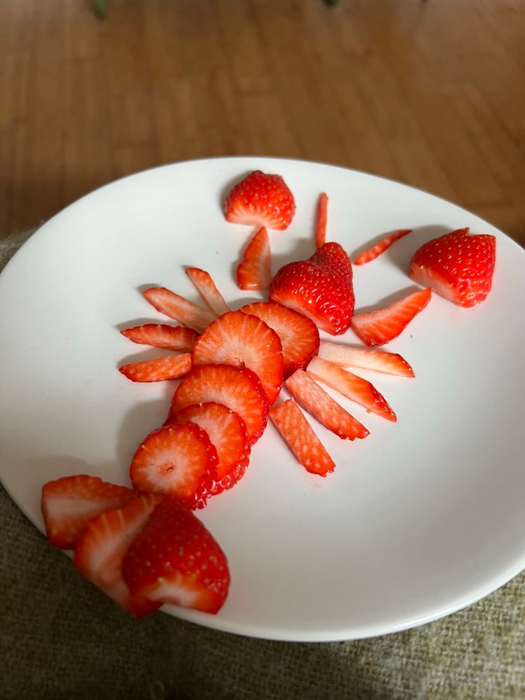 Strawberries on a plate, sliced to look like a lobster