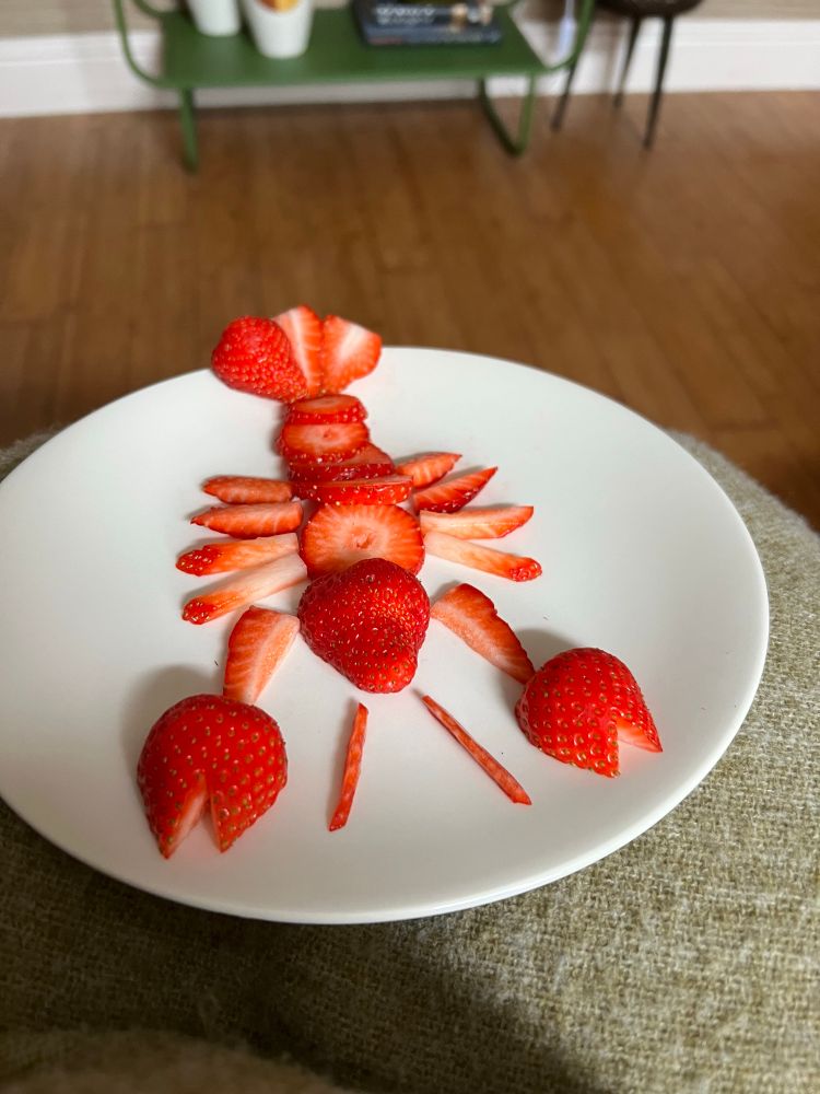 Strawberries on a plate, sliced to look like a lobster