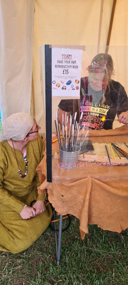 Customer turning her first glass bead with the expert Scarlet instructing at a safe distance from the blowtorch!