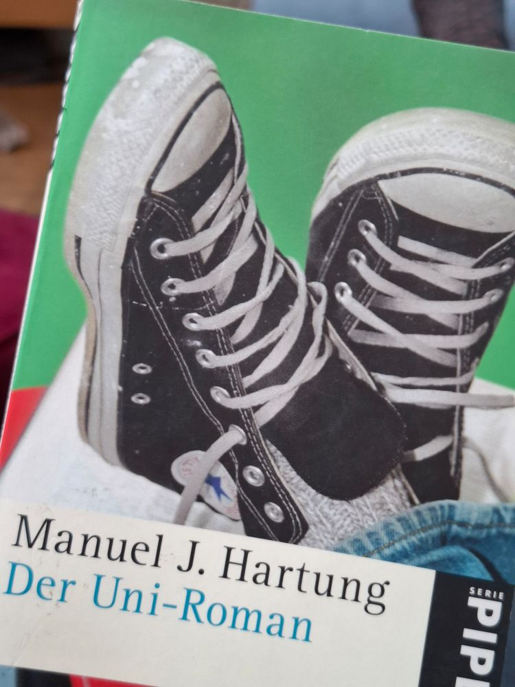 Buchcover mit zwei Turnschuhen: "Der Uni-Roman" von Manuel J. Hartung