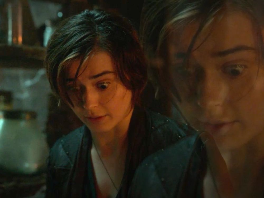 Kate Tanthalos from Willow tv show being shocked and looking down, with a remnant and translusant exact same image of herself but sightly bigger next to her