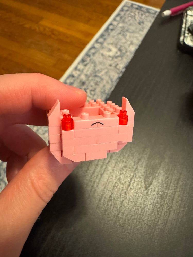 Kirby nanoblock in the early stages: just some pink blocks, an angry grin, and the red of Kirby’s angry eyes.
