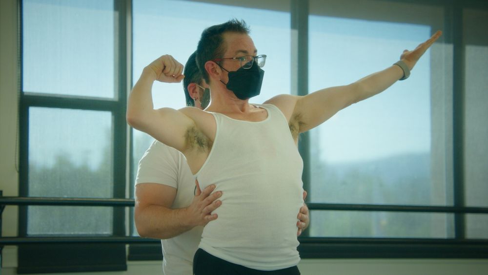 My trainer standing behind me with his hands on my waist while I get into a bodybuilding pose. We look like we are dirty dancing