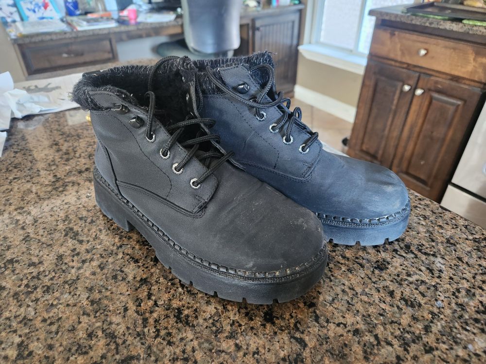 Thick soled black boots on a kitchen counter 