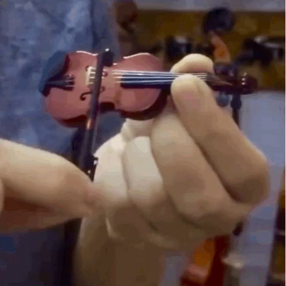 a person is holding a small pink violin in their hand