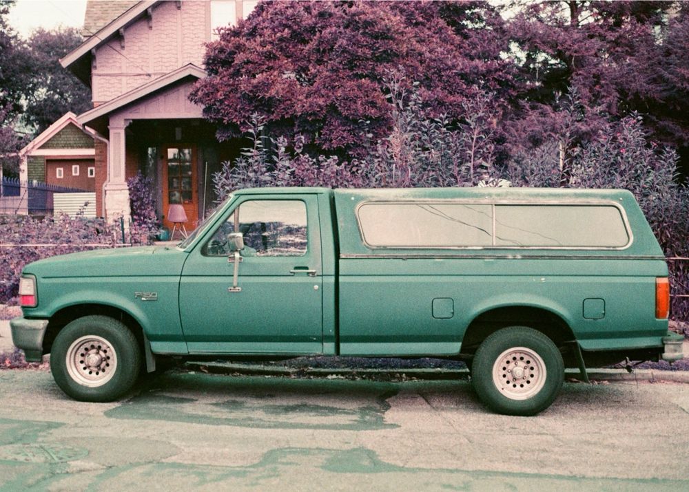 A photo of a truck on a modified film that makes grass and plants look pink and purple.