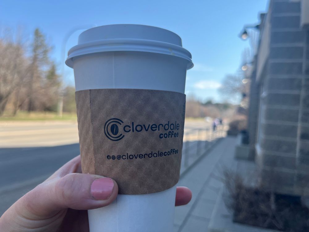 Coverdale Coffee cup in front of street where the store is located 