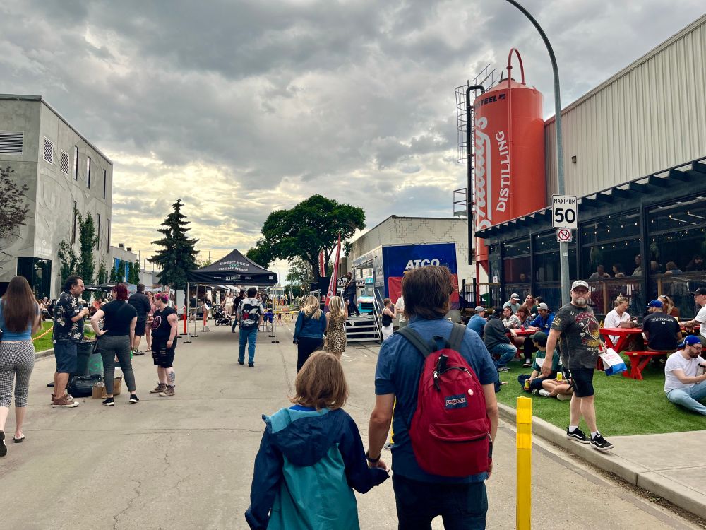 Shiddy’s Birthday Block Party. People walking in the street, eating and enjoying the music. 