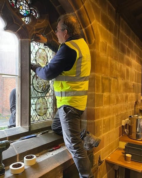 Stained glass conservator Jim Budd installing a window with flemish roundels at St. Mary's Shrewsbury.