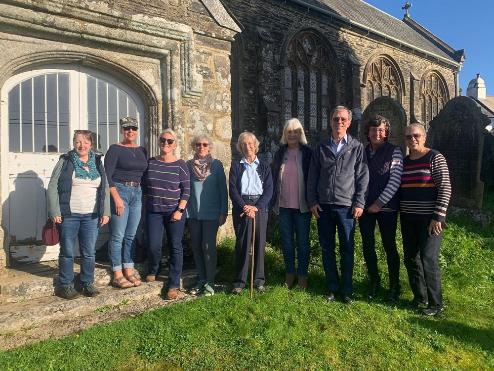 North Huish Team outside the church on a sunny day, posing for a photo, smiling