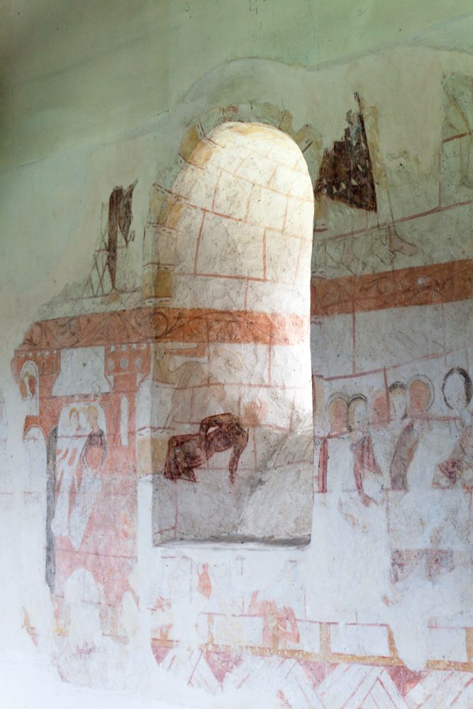 13th Century wall paintings clustered around a window at St. Thomas A Becket, Capel, Kent. We can see scenes from the story of Cain & Abel, decorative patterns and a scene with many people, possibly the last supper. Image (c) Andy Marshall