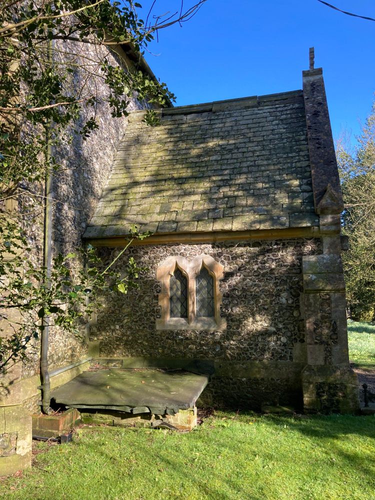 St. Mary's sun-speckled porch with flint walls and slate roof (c) Maria Luisa Latorre