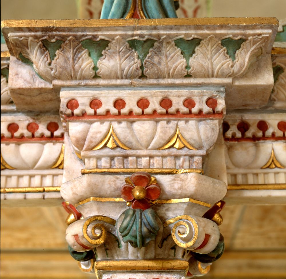 Monument detail looking like a decorated cake, painted with green, red and gold details.