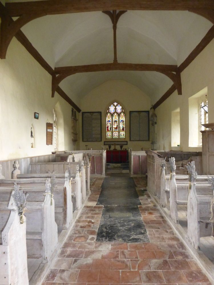 Church interior of St. Mary's, Badley, a plain post-reformation church with whitewashed walls and pews with poppyheads.