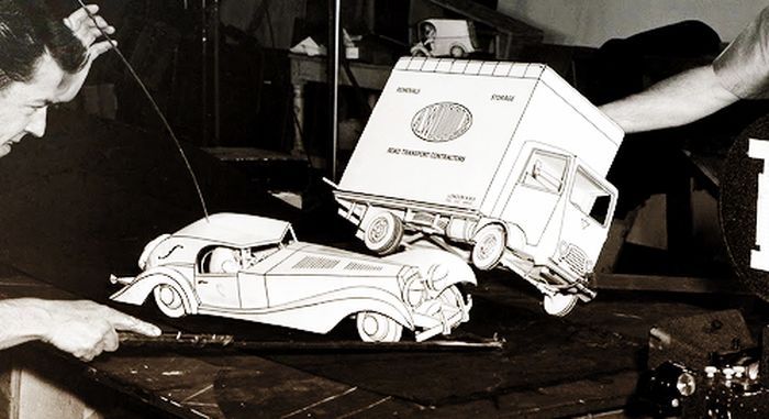 Animators posing cardboard cars for filming