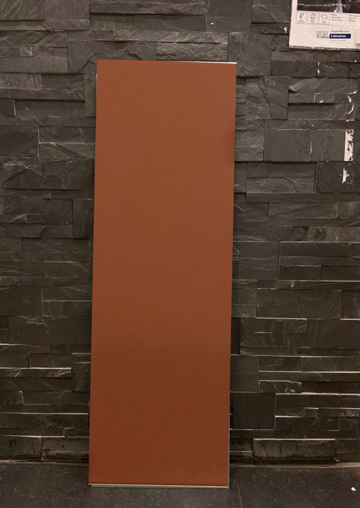 Carrelage 30 x 90 cm couleur terracotta mat devant mur de carrelage effet briques en pierre noires / anthracites