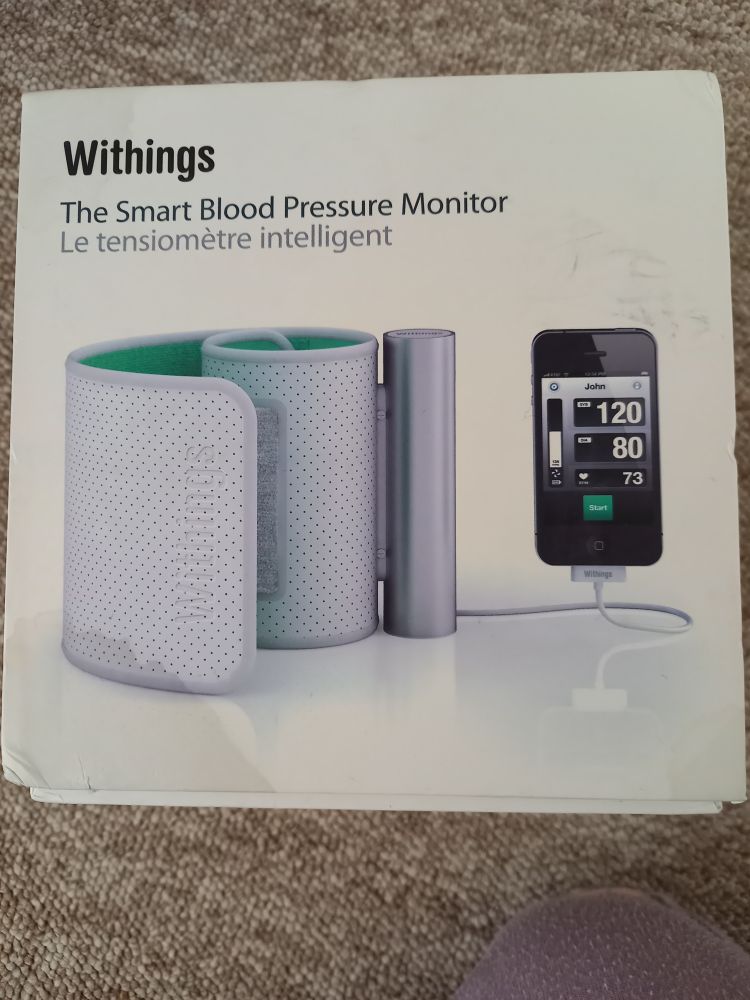 Withings bp monitor box. It shows the monitor with an I-phone next to it. 
Text says "the smart blood pressure monitor" and in French "le tensiomètre intelligent". 