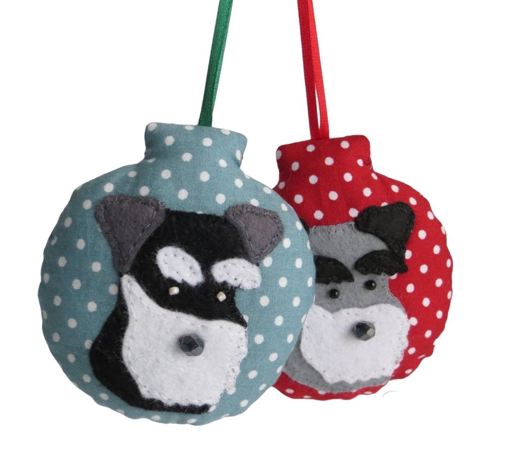 A pair of handmade polka dot fabric lavender scented baubles in red and green, with black and grey schnauzer dog felt motifs by misheleneous