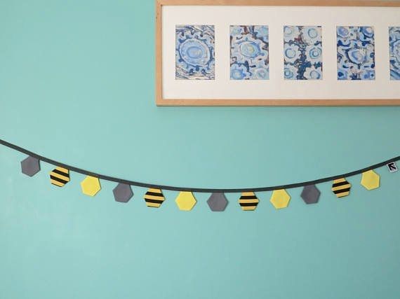 Black and yellow, striped and grey fabric, hexagon flag bunting length pictured on a turquoise wall