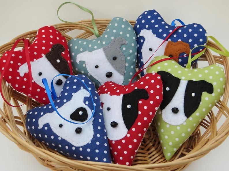 A small wicker basket filled with various coloured, spotty fabric lavender heart ornaments with felt staffie dog head motifs by misheleneous
