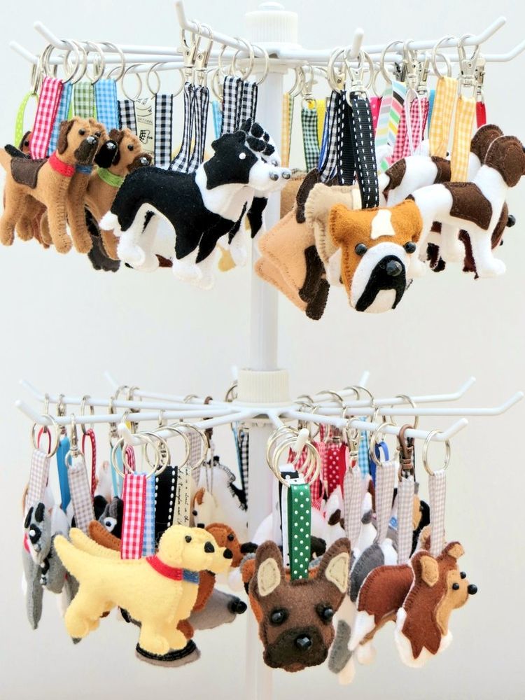 A white metal jewellery display stand hung with handmade felt kennel club dog breed keyrings and bag charms by misheleneous
