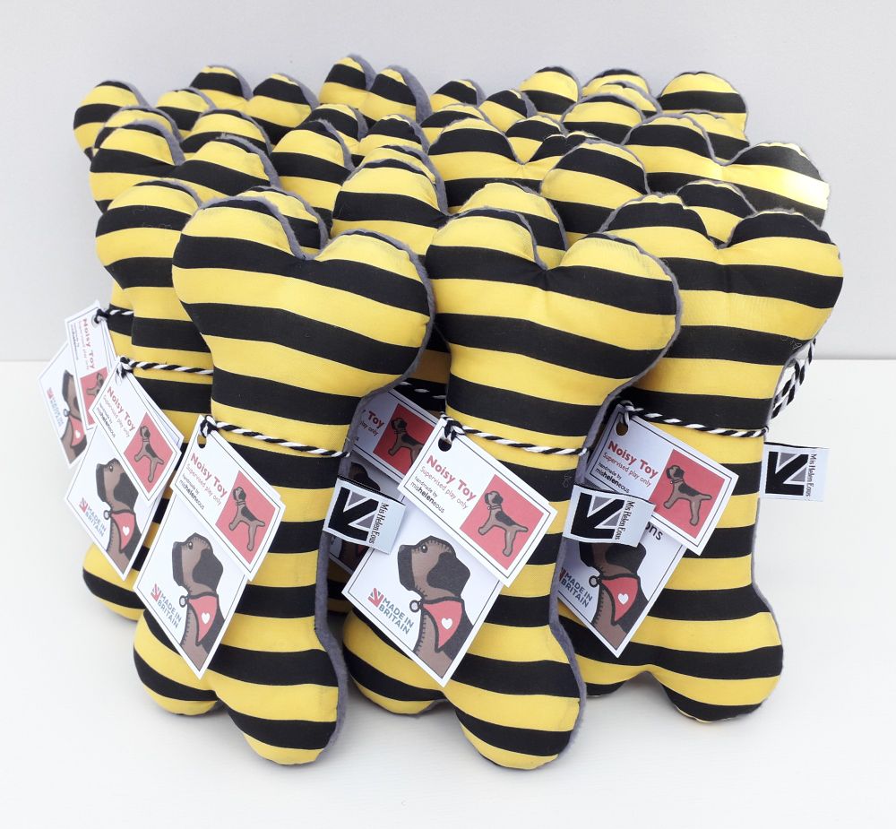 A group of yelloe and black stripe fabric squeaky dog bone toys. Handmade by misheleneous for manchesterbeeco