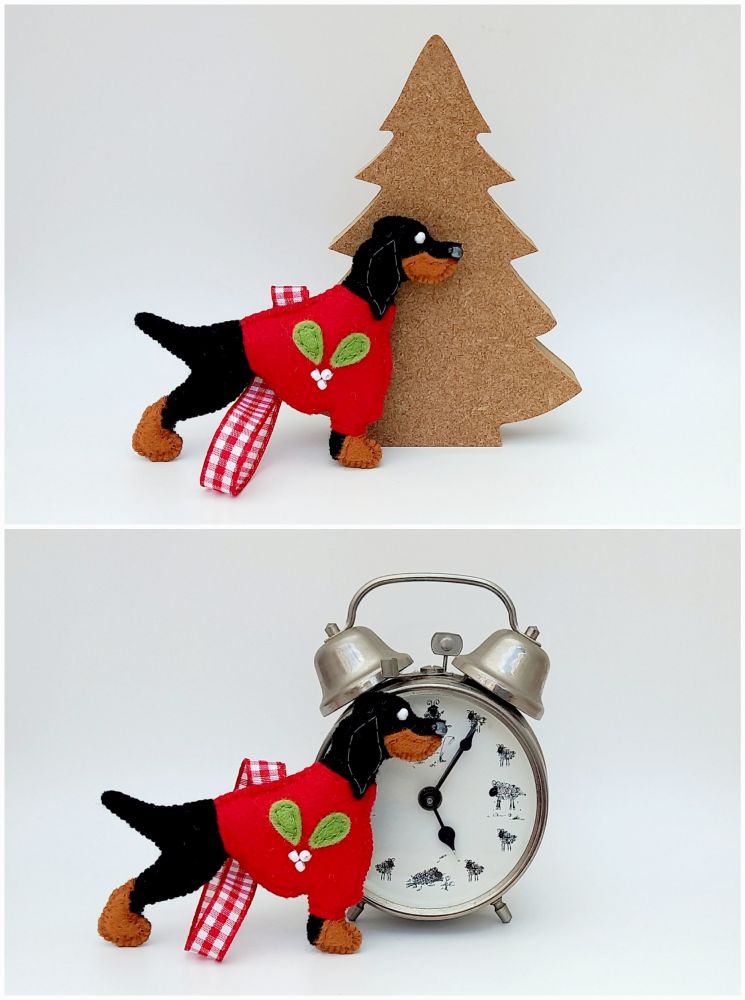 A felt handmade Gordon Setter christmas ornament by misheleneous. It has a red festive jumper with mistletoe motif and coordinating gingham hanging ribbon