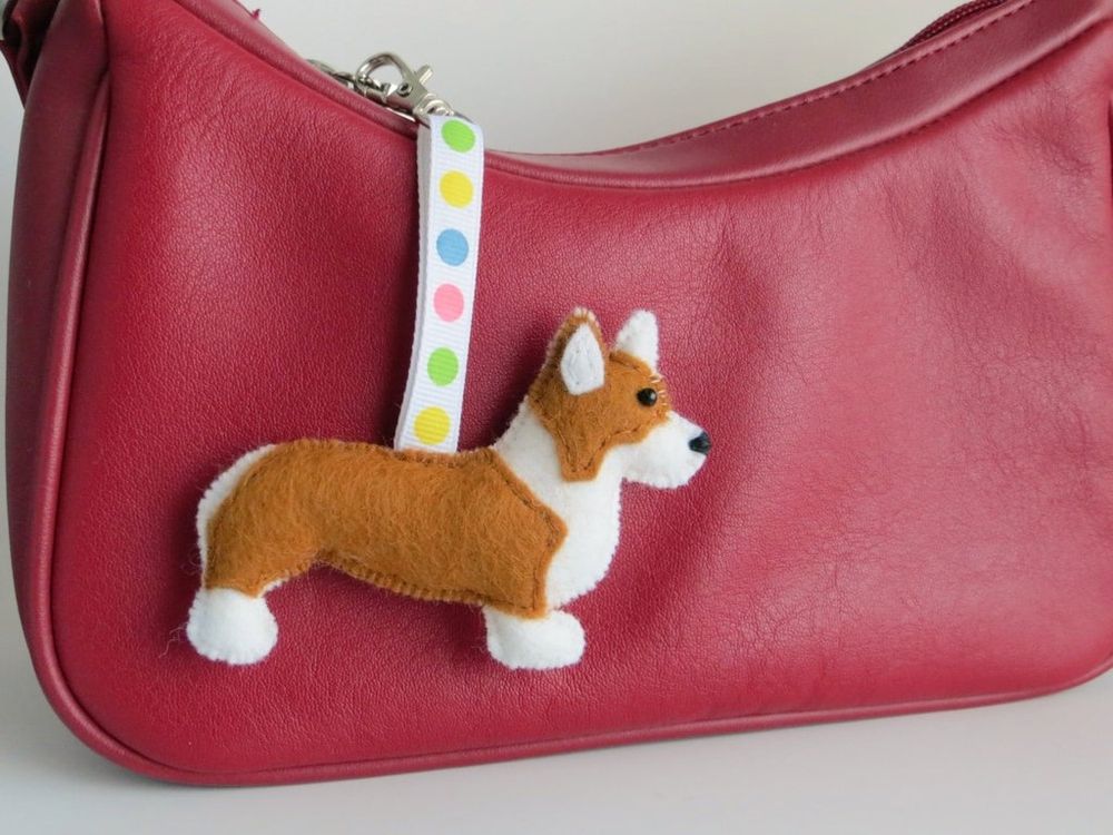 A handmade felt pembroke welsh corgi dog charm by misheleneous. Attached to a small red handbag